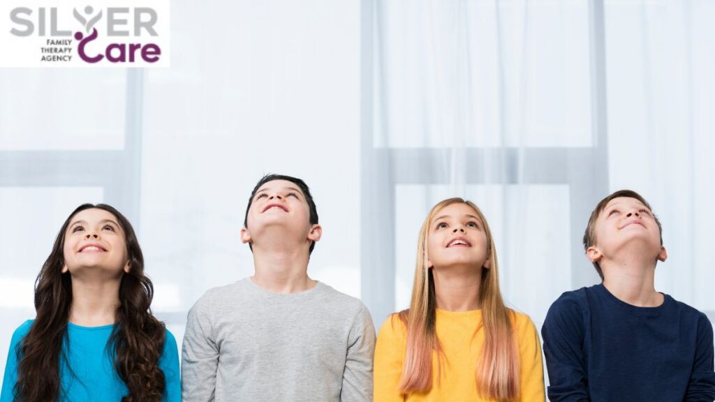 A group of children look up at the ceiling, appearing relaxed and connected.